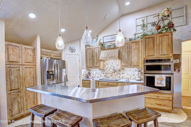 kitchen featuring a kitchen breakfast bar, backsplash, stainless steel appliances, vaulted ceiling, and pendant lighting