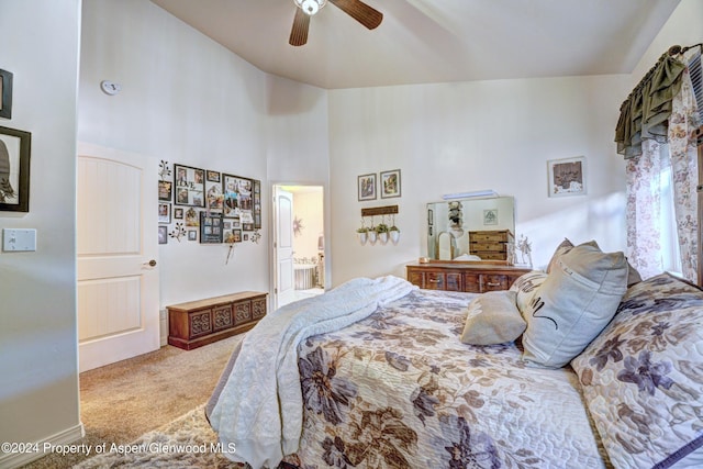 bedroom with ceiling fan, carpet floors, and a high ceiling