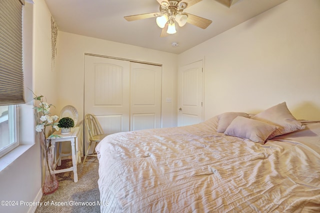 carpeted bedroom with ceiling fan and a closet