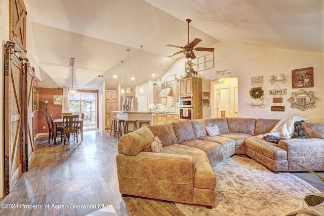 living room with light wood-type flooring, high vaulted ceiling, and ceiling fan