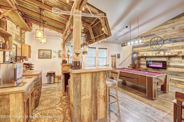 playroom with light hardwood / wood-style flooring, vaulted ceiling, rustic walls, and pool table