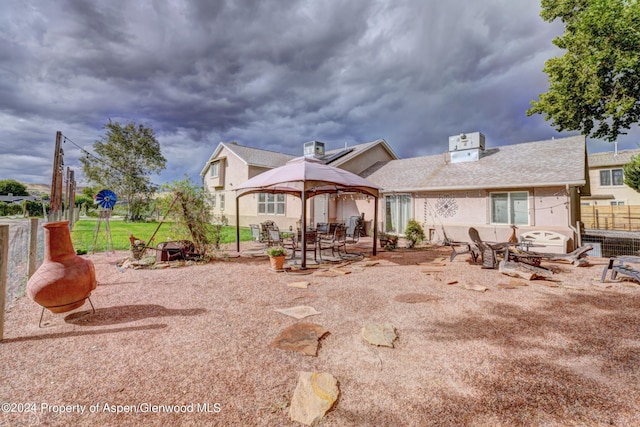 back of house with a fire pit and a patio area