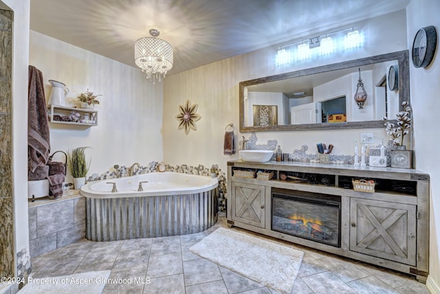 bathroom with a notable chandelier, vanity, a relaxing tiled tub, and tile patterned floors