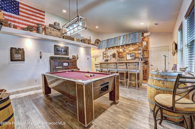 rec room featuring wood-type flooring, high vaulted ceiling, bar, and billiards