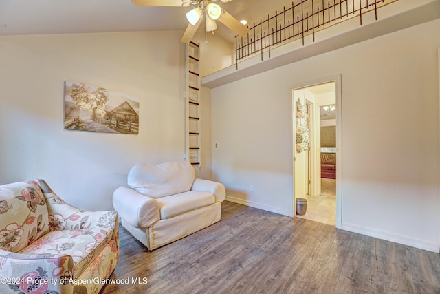 living area with hardwood / wood-style floors, ceiling fan, and high vaulted ceiling