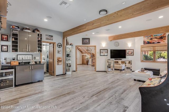 living room with beamed ceiling, light wood-type flooring, and beverage cooler