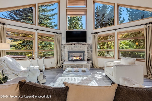 sunroom with a stone fireplace and lofted ceiling