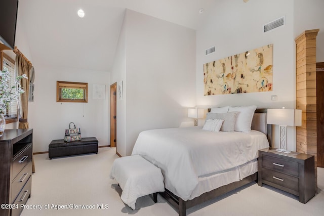 carpeted bedroom with high vaulted ceiling