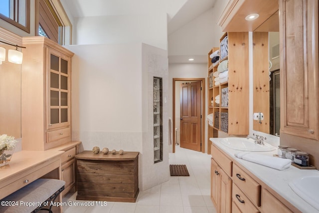 bathroom with tile patterned flooring, a towering ceiling, and vanity