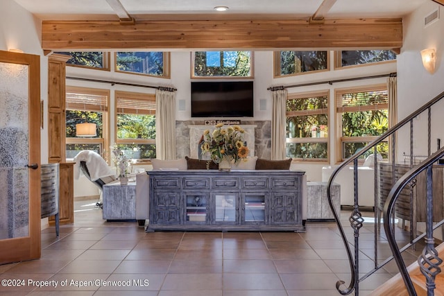 living room featuring beam ceiling, dark tile patterned flooring, high vaulted ceiling, and a wealth of natural light