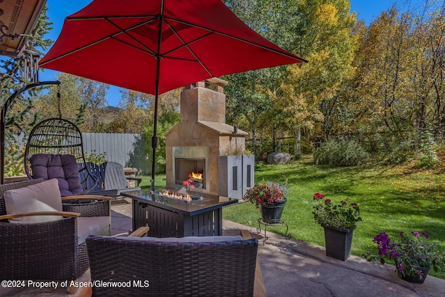 view of patio / terrace with an outdoor stone fireplace and an outdoor fire pit