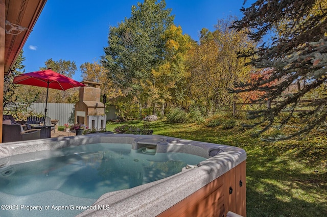 view of pool with a yard and a hot tub