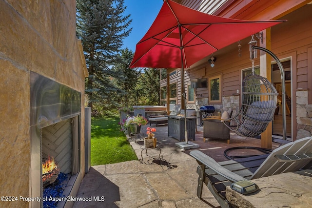 view of patio with area for grilling and exterior fireplace