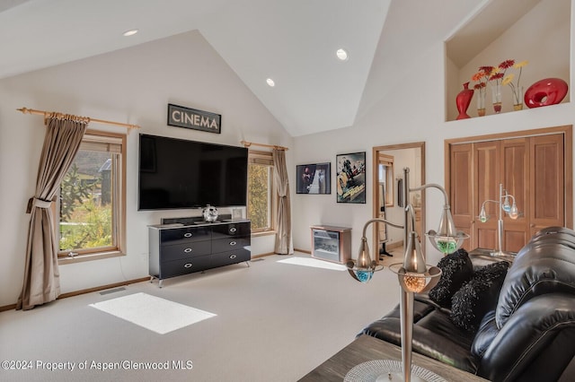 living room with light colored carpet and high vaulted ceiling