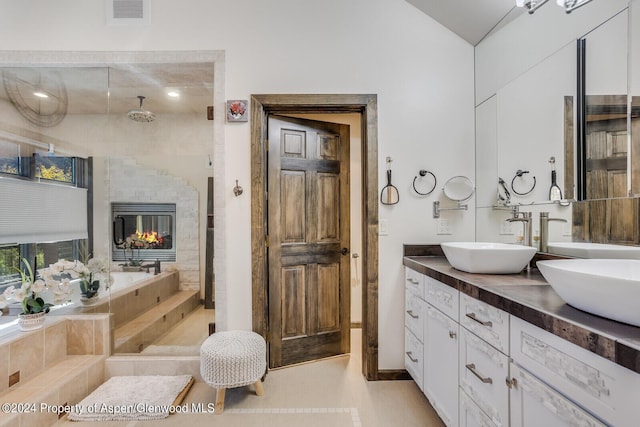 bathroom with vanity, tiled bath, and tile patterned floors