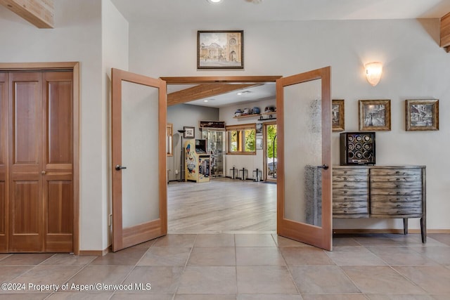 hall with french doors and light tile patterned floors