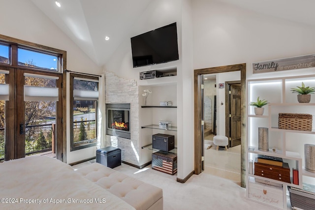 bedroom with a fireplace, light carpet, and high vaulted ceiling