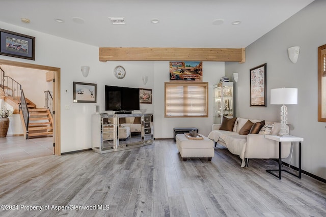 living room featuring beamed ceiling and light wood-type flooring