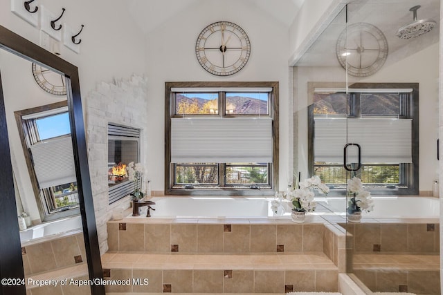 bathroom featuring a relaxing tiled tub and vaulted ceiling