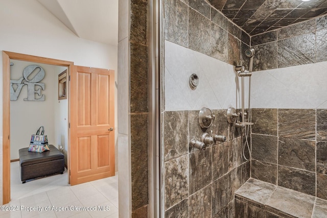 bathroom with tile patterned flooring and a tile shower