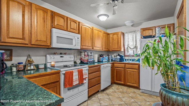 500 Fairway Ave, Rifle, CO 81650 - kitchen with white appliances, brown cabinetry, a ceiling fan, dark countertops, and a sink