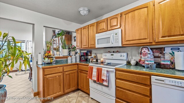 500 Fairway Ave, Rifle, CO 81650 - kitchen with white appliances, light tile patterned floors, and brown cabinetry
