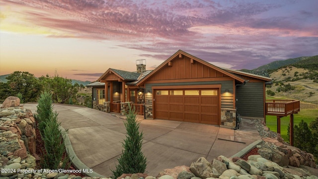 view of front of home with a deck with mountain view and a garage