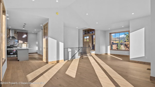 interior space with light hardwood / wood-style floors and vaulted ceiling