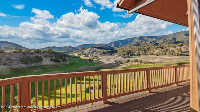 wooden deck with a lawn and a mountain view