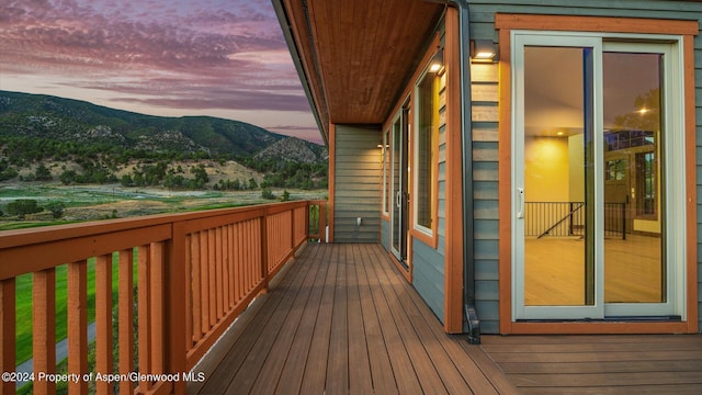 deck at dusk featuring a mountain view