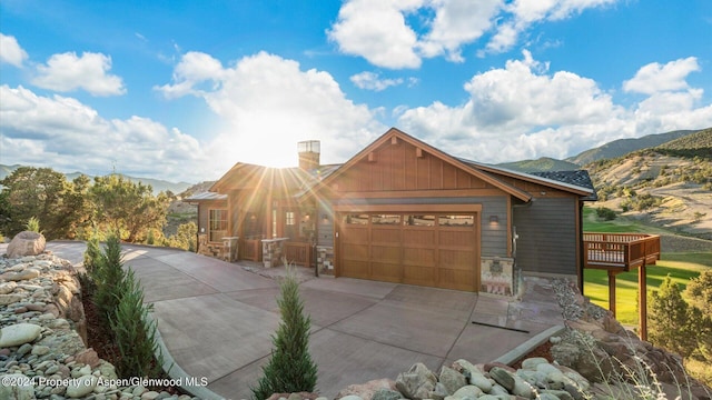 view of front of home with a deck with mountain view and a garage