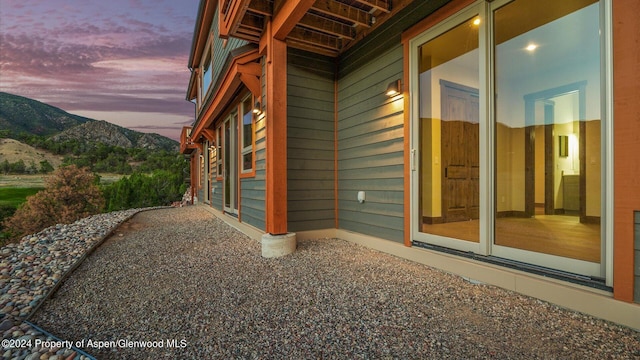 property exterior at dusk featuring a mountain view