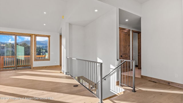 staircase featuring hardwood / wood-style floors and high vaulted ceiling