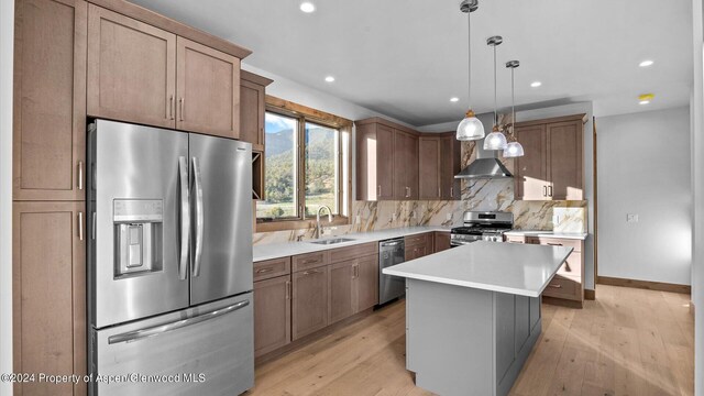 kitchen with a center island, sink, decorative backsplash, decorative light fixtures, and stainless steel appliances