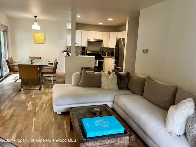 living room featuring plenty of natural light, sink, and light hardwood / wood-style floors