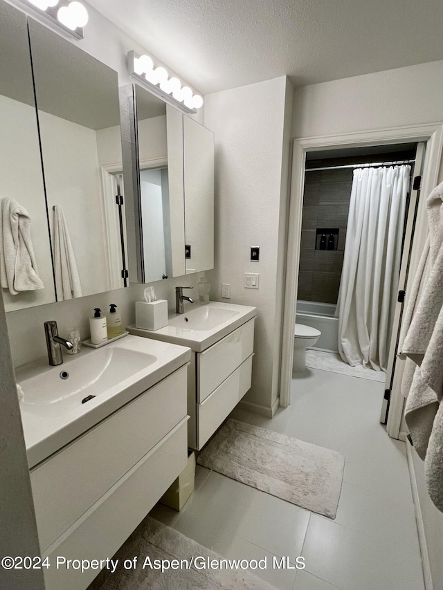 full bathroom featuring vanity, shower / bathtub combination with curtain, a textured ceiling, and toilet