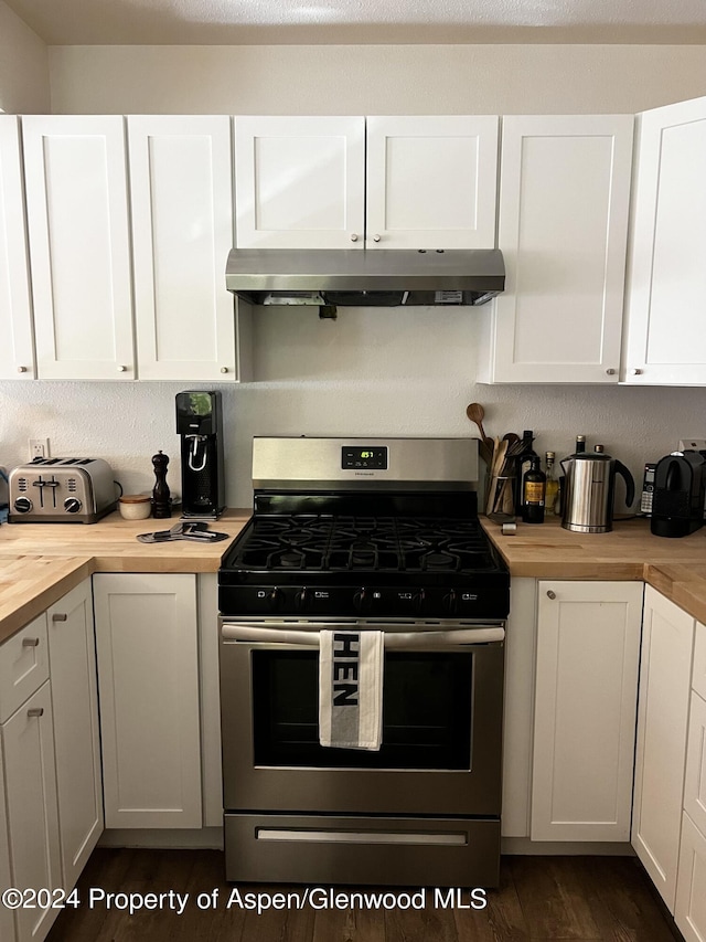 kitchen with butcher block counters, dark hardwood / wood-style flooring, white cabinetry, and stainless steel gas range