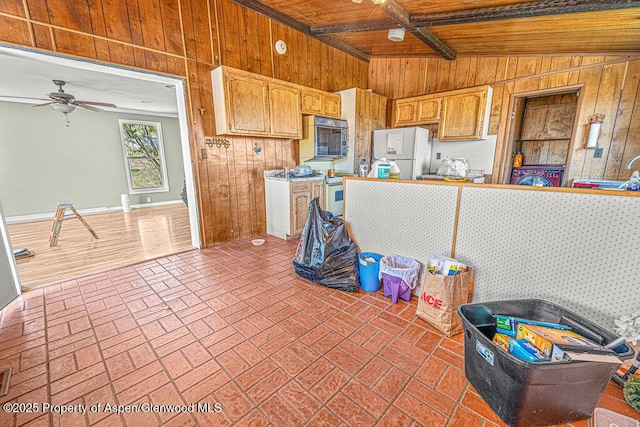 5990 County Road 7, Craig, CO 81625 - kitchen with wooden walls, freestanding refrigerator, wood ceiling with exposed beams, a ceiling fan, and brick patterned flooring