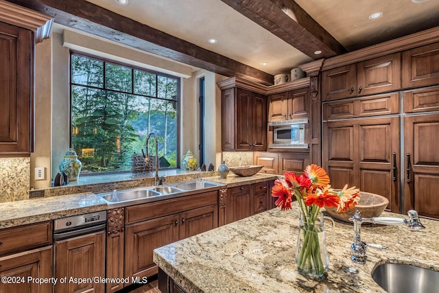 kitchen featuring beam ceiling, stainless steel microwave, sink, and tasteful backsplash