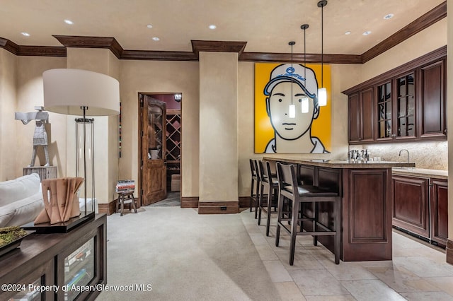 bar with dark brown cabinetry, light colored carpet, pendant lighting, and ornamental molding