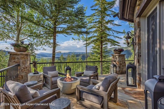 view of patio with a mountain view and an outdoor fire pit