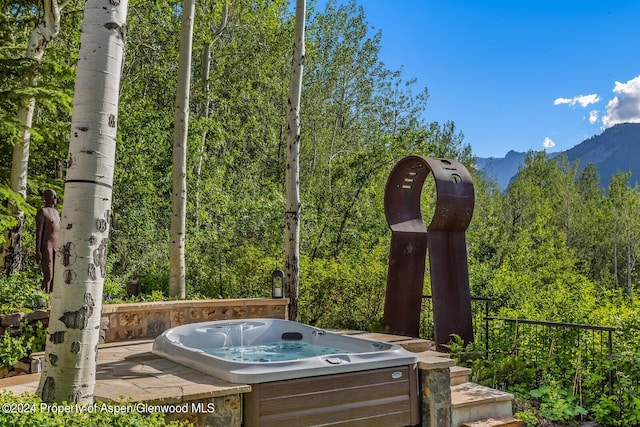 view of patio featuring a mountain view and a hot tub