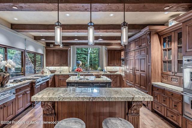 kitchen featuring hanging light fixtures, a breakfast bar, a kitchen island, and light hardwood / wood-style floors