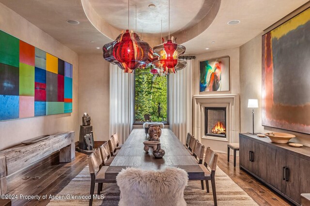 dining space with a tray ceiling and wood-type flooring