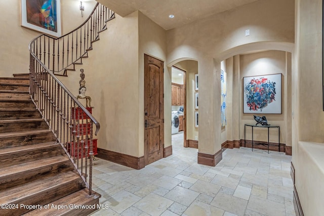 entrance foyer with washer / dryer and a towering ceiling