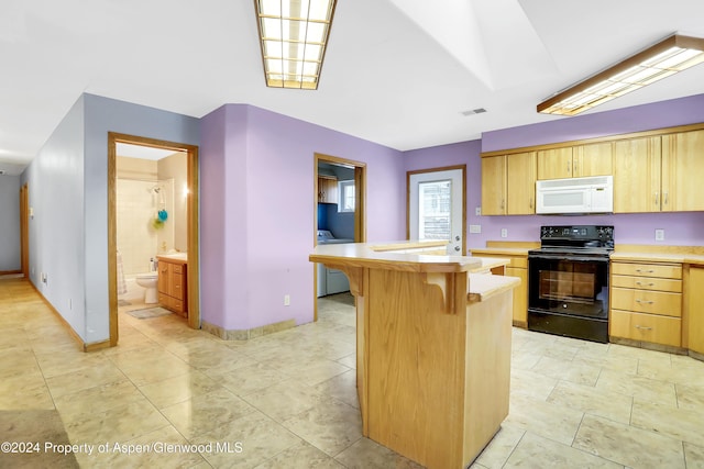 kitchen featuring a breakfast bar, light brown cabinets, electric range, and a center island