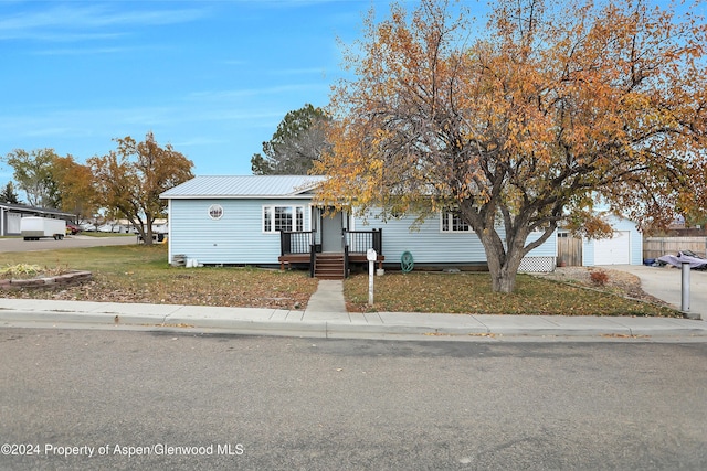 view of front of home with an outbuilding, a front lawn, and a garage