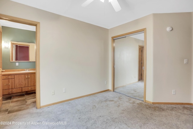 empty room featuring ceiling fan, sink, and light colored carpet