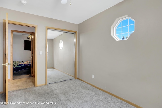 unfurnished bedroom featuring carpet flooring and a closet