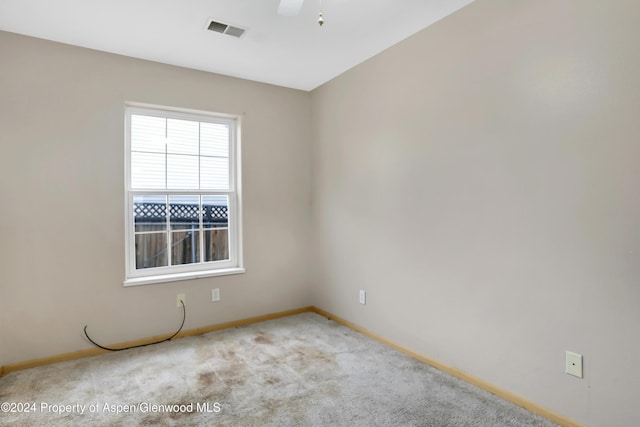 spare room with ceiling fan and light colored carpet